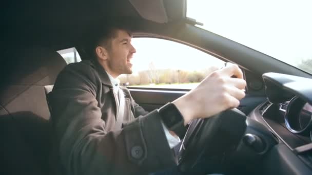 Ευτυχής επιχειρηματίας όμορφος οδήγηση αυτοκινήτου και το τραγούδι. Ο άνθρωπος είναι ευτυχισμένος μετά κάνοντας προσφορές και δίσκους σπίτι — Αρχείο Βίντεο