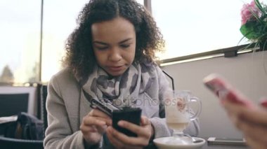 Kredi kartı ile smartphone sokak Cafe alışveriş online kullanarak yarış kadın karışık Attrcative closeup var onun arkadaşı ile kahve molası