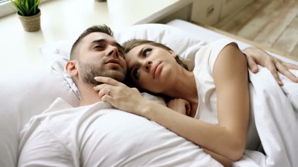Nahaufnahme von jungen schönen und liebevollen Paar reden und umarmen sich ins Bett, während sie morgens aufwachen. — Stockvideo