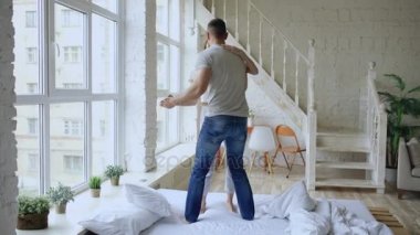 Genç güzel ve sevgi dolu çift dans ve sabahları evde yatakta öpüşme