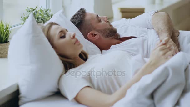 夫婦関係の問題、自宅のベッドで横になって感情的な会話とのクローズ アップ。若い女性が彼氏を向ける — ストック動画