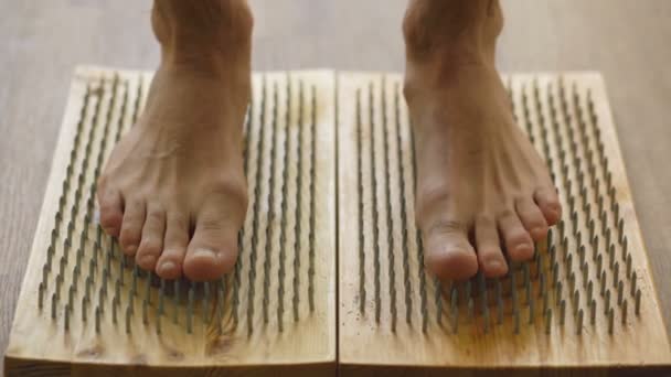 Closeup of yoga man stand on board with sharp nails — Stock Video