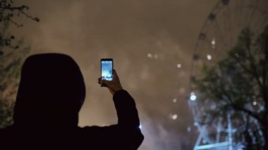 Closeup siluet izlemek ve havai fişek çekim adam açık havada smartphone kamerada patlayabilir