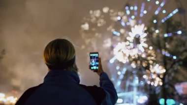 Closeup siluet izlemek ve havai fişek çekim adam açık havada smartphone kamerada patlayabilir