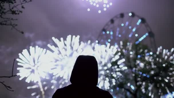 Силуэт крупного плана одинокого человека, смотрящего фейерверк на праздновании Нового года на открытом воздухе — стоковое видео