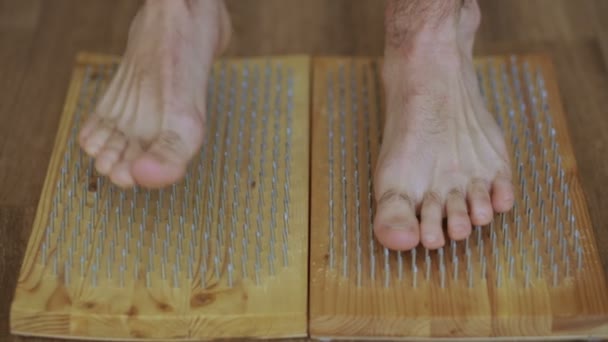 Крупный план йоги мужчина стоит на борту с острыми ногтями — стоковое видео