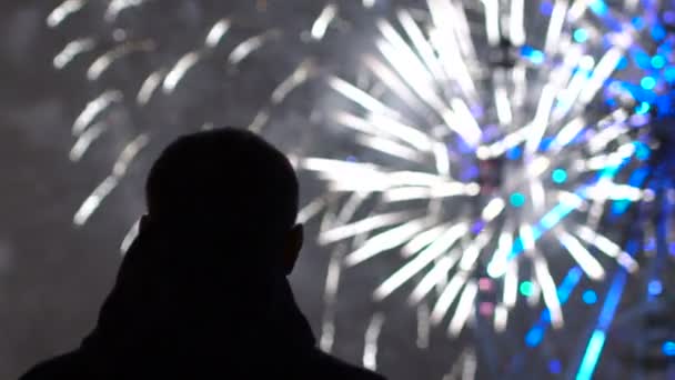 Zeitlupe der Nahaufnahme Silhouette eines einsamen Mannes, der Feuerwerk auf der Silvesterfeier im Freien anschaut — Stockvideo