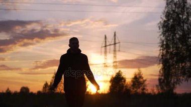 Sunset bulvarında Şehir Parkı ip atlama ile eğitim genç adam tekme boksör silüeti