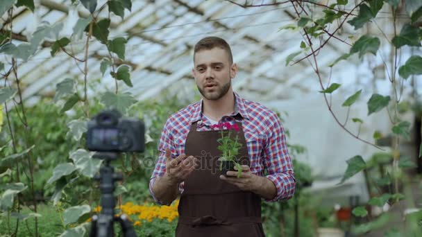 年轻人微笑围裙控股博客人花店花说话和记录他对园艺的在线沃客的视频博客 — 图库视频影像