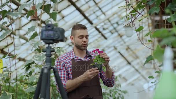 年轻人微笑围裙控股博客人花店花说话和记录他对园艺的在线沃客的视频博客 — 图库视频影像
