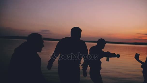 Silhouette di gruppo giovani ballerini danno una festa in spiaggia al tramonto — Video Stock