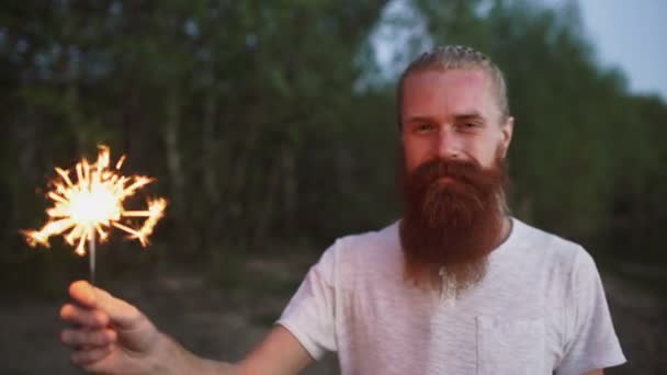 Portré, fiatal, mosolygós ember csillagszóró ünnepli a beach party — Stock videók