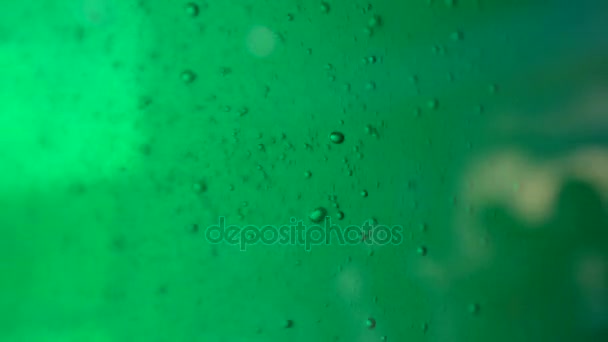 Крупним планом повітряні бульбашки піднімаються в зеленій киплячій воді — стокове відео