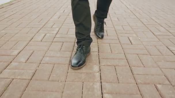 Steadicam skott av närbild Visa affärsman i skor går framåt trottoaren på street — Stockvideo
