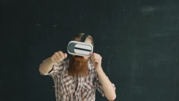 Slowmotion av Bearded man klädd i virtuell verklighet headset spelar Vr fightingspel på svart bakgrund — Stockvideo