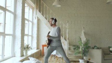Slowmotion komik sakallı adam dans şarkı ve evde yatak odasında elektro gitar çalmak yatakta