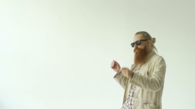 Beyaz arka plan üzerinde dans güneş gözlüklü genç komik sakallı adamın Slowmotion
