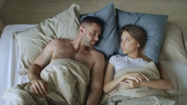 Junges schönes und liebevolles Paar plaudert und hat Spaß im Bett — Stockvideo