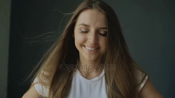 Retrato de jovem mulher sorridente com cabelo voando de vento — Vídeo de Stock