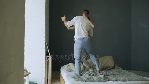 Jonge mooie en liefdevolle paar dansen en zoenen op het bed in de ochtend — Stockvideo