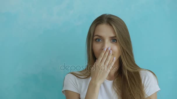 Porträtt av ung kvinna aktivt överraskande och undrar nu tittar in kameran på blå bakgrund — Stockvideo