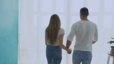 Pencere açık perdeleri için yürüyüş ve birbirimizi yeni evde öpüşme sevgi dolu çift kucaklama, Steadicam vurdu