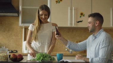 Çekici çift erken sabah mutfakta ve tablet bilgisayar kullanarak online video sohbet