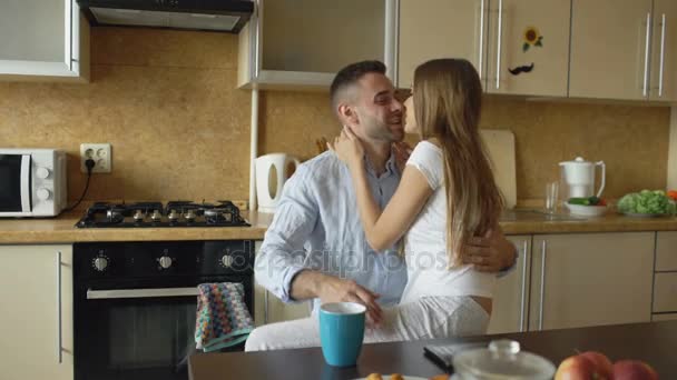 魅力的なカップルを満たす台所で早朝とソーシャル メディア サーフィンのデジタル タブレット コンピューターを使用して — ストック動画