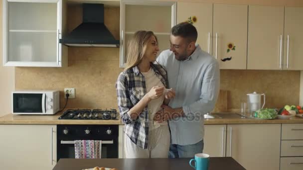 Attraktiva flicka visar graviditetstest resultat till sin pojkvän och surpise honom vid köket — Stockvideo