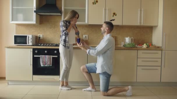 Jovem fazendo proposta para sua namorada na cozinha em casa — Vídeo de Stock