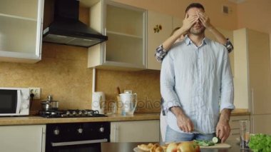 Eller erkek gözlerle kapsayan ve onu evde mutfakta şaşırtıcı genç kadın