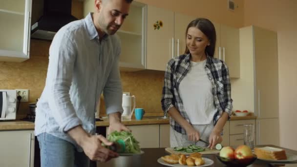 Heureux jeune couple cuisiner le petit déjeuner ensemble dans la cuisine tôt le matin — Video