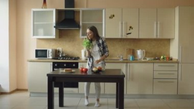 Dans ve marul mikrofon ile kahvaltı yemek yaparken şarkı neşeli genç komik kadın