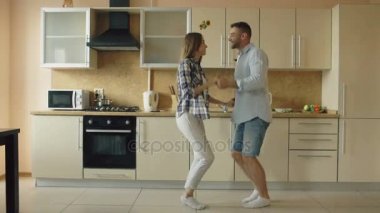 Çekici genç neşeli çift evde mutfakta yemek yaparken dans eğlenceli