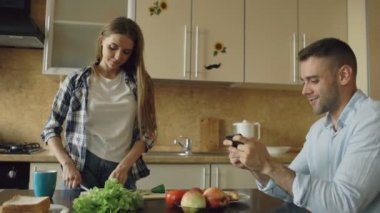 Çekici çift mutfakta. Adam akıllı kız arkadaşı yemek sırasında video oyun oynarken