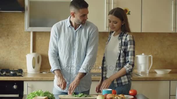 Gelukkige jonge paar in de keuken. Knappe man ontmoeten en diervoeders zijn vriendin vroeg in de ochtend — Stockvideo