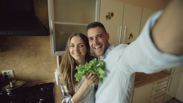 POV Joven pareja feliz tomando foto selfie mientras se cocina el desayuno en la cocina en casa — Vídeos de Stock