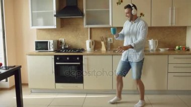 Yakışıklı genç komik dans ve sabahları evde mutfak şarkı Kulaklığımda dostum ve tatile eğlenin