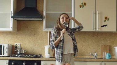 Yavaş dans ve mutfakta yemek yaparken ise kepçeyle şarkı neşeli genç komik kadın