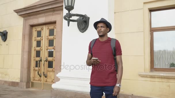 Afryki amerykański turysta człowieka za pomocą smartphone online mapę aby znaleźć właściwe wskazówki dojazdu, stojący przy ulicy — Wideo stockowe