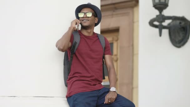 Αφρικανική αμερικανική τουριστική άνθρωπος κουβεντιάζοντας με smartphone στέκεται κοντά σε ιστορικό κτίριο στην Ευρώπη — Αρχείο Βίντεο