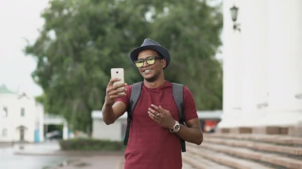 Avrupa'da seyahat ederken onun smartphone kamera kullanarak online görüntülü sohbet sahip mutlu Afrika kökenli Amerikalı turist adam — Stok video