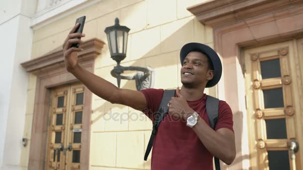 Carrera mixta feliz turista tomando foto selfie en su cámara de teléfono inteligente de pie cerca del famoso edificio en Europa — Vídeo de stock