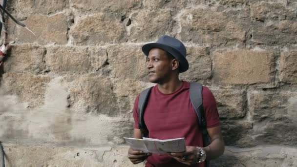 Mixte homme touristique de course marchant et regardant papier carte de la ville pour trouver des directions à l'endroit célèbre — Video