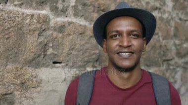 Gülümseyen ve kameraya bakarak mutlu Afrika turistik adam backpacker Portriat. Karışık yarış genç adam Avrupa'da seyahat