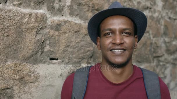 Portriat του backpacker άνθρωπος ευτυχισμένος Αφρικής τουριστική χαμογελώντας και κοιτώντας την κάμερα. Μικτή φυλή νεαρός Ταξιδεύοντας στην Ευρώπη — Αρχείο Βίντεο