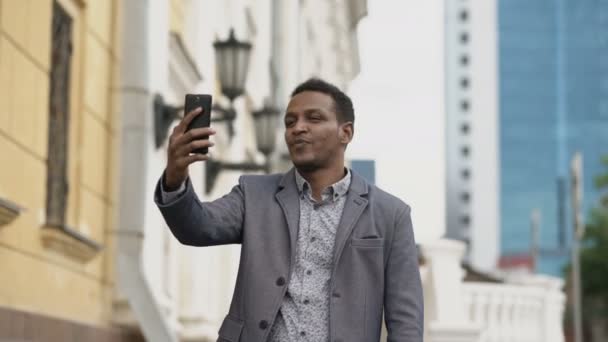 Empresario de carrera mixta que tiene chat de vídeo en línea en conferencia de negocios con teléfono inteligente — Vídeo de stock