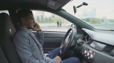 Onun araba açık havada içinde otururken telefonu konuşurken mutlu karışık yarış işadamı