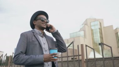 Steadicam atış mafya adamın takım elbise ve konuşmak telefon ve açık havada sokakta yürürken güneş gözlüğü