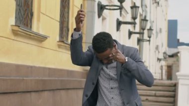 Ağır çekim smartphone vasıl konuşuyor ve yapma hakkında mutlu dans karışık yarış işadamı açık havada baş